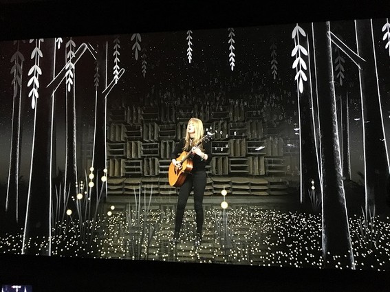 Photo: Beatie Wolfe singing with augmented reality illustrations around her. Photo Credit: Esther Surden