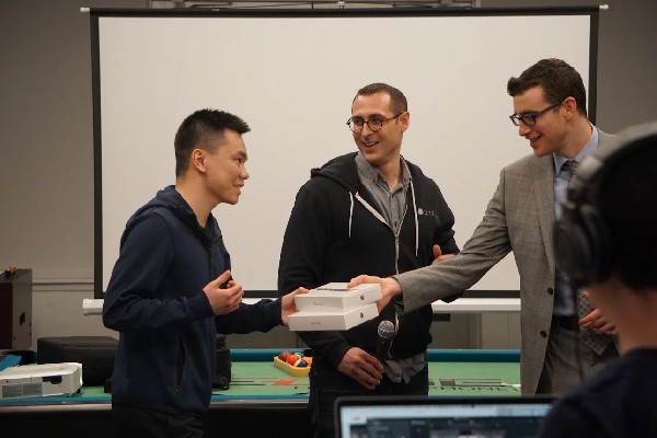 Photo: Jacob Jonas hands iPads to Shaoliang Zhong of Stevens University. Jonathan Hyman CTO of Appboy is in the center. Photo Credit: Courtesy IDT Corp.