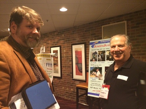 Photo: Mark Annett talks to exhibitor Andrew Hines of Screen Suspender. Photo Credit: Esther Surden