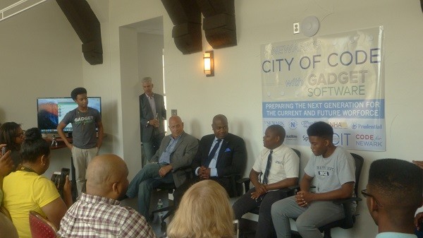 Photo: Panel at the community meeting at Gadget Software including L-R Dan Crain, Mayor Ras J. Baraka and two students who had learned coding through the city program. Photo Credit: Courtesy Gadget Software