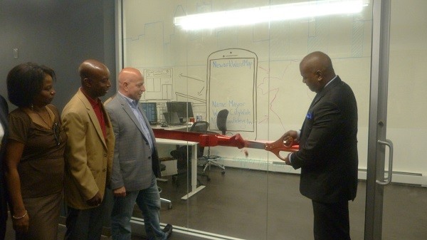 Photo: Newark Mayor Ras J. Baraka (R) cuts the ceremonial ribbon at Gadget Software with CEO Dan Crain, COO Maxwell Riggsbee and Allison Durham, executive manager of the Newark Housing Authority. Photo Credit: Courtesy Gadget Software