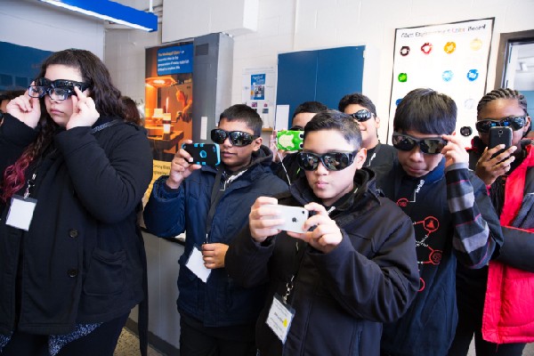 Photo: Students don protective glasses to watch glass-making experiment. Photo Credit: Malcolm Brown for Verizon