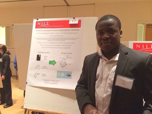 Photo: NJIT's Ronald Forson with his poster about a solar powered wireless charger. Photo Credit: Esther Surden